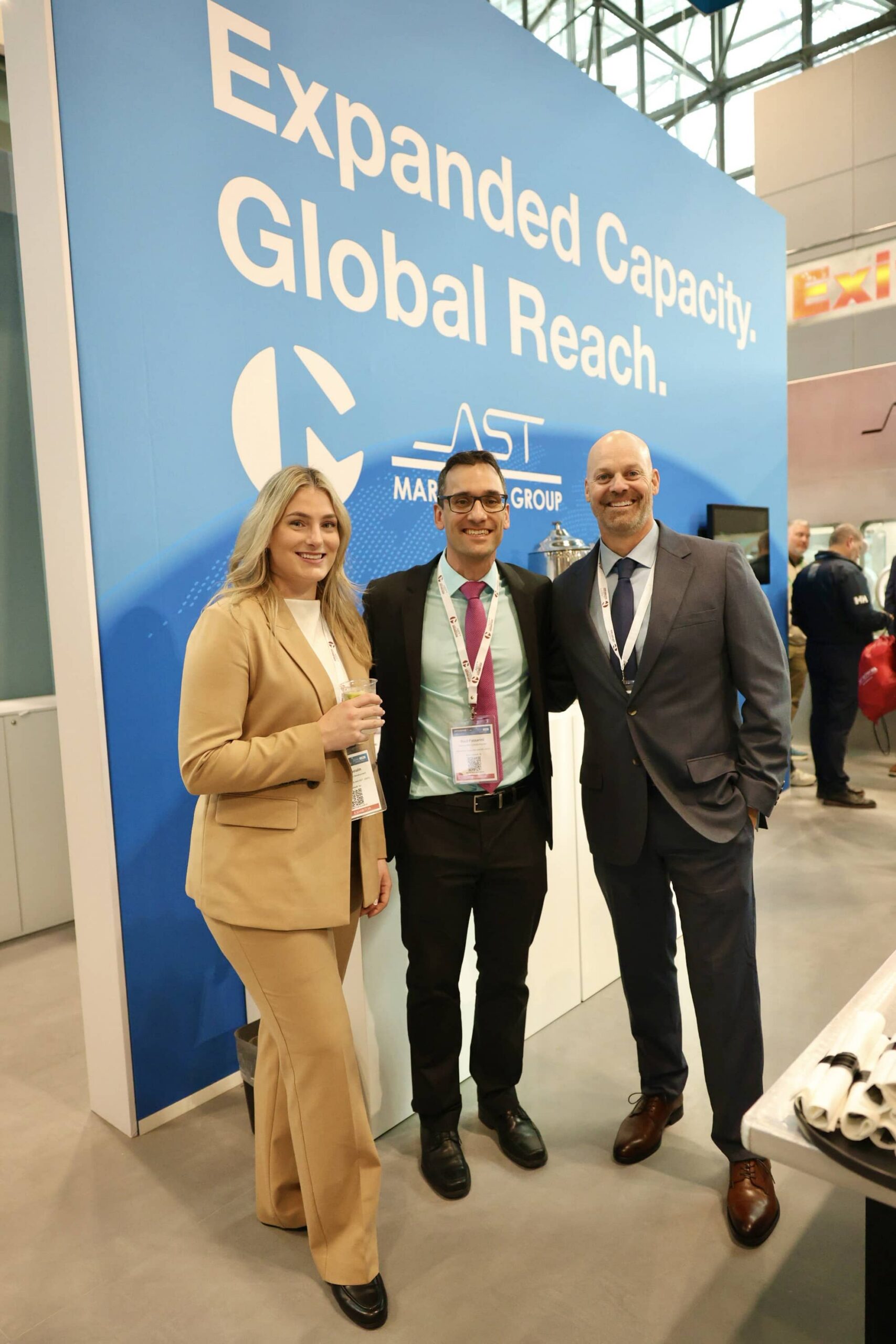 AST team members in front of the AST and Marchesini Group co-branded banner at INTERPHEX 2026 noting the expanded capacity and global reach of aseptic manufacturing solutions.